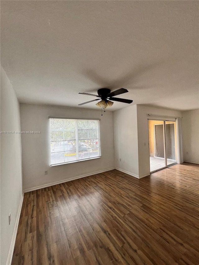 unfurnished room featuring dark hardwood / wood-style floors, ceiling fan, and a textured ceiling