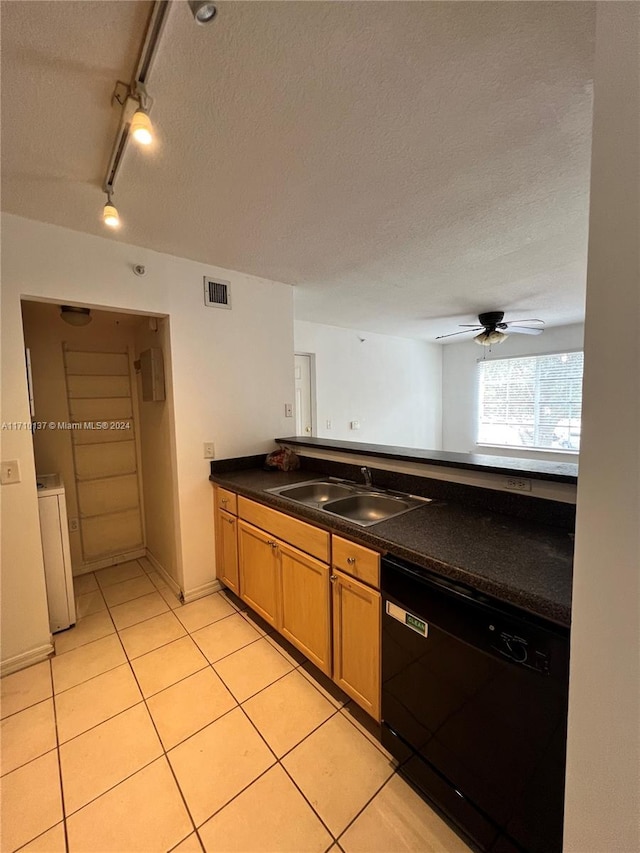 kitchen featuring sink, rail lighting, black dishwasher, washer / dryer, and light tile patterned floors