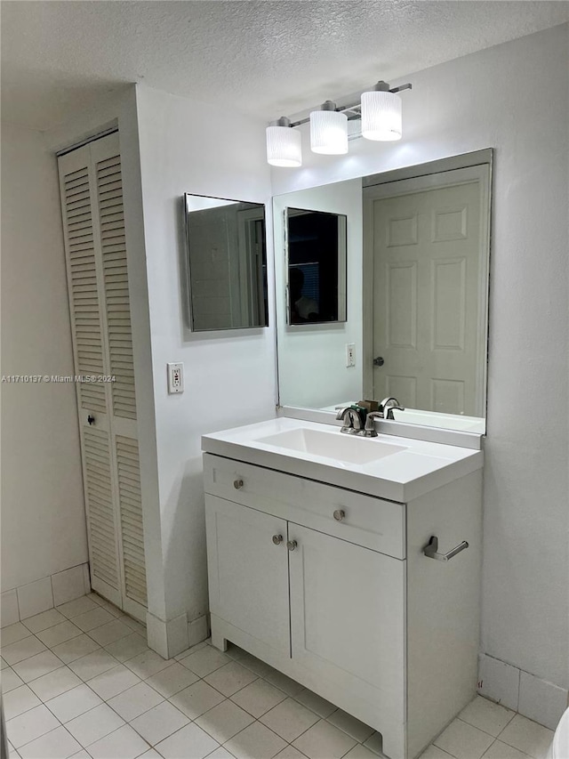 bathroom featuring tile patterned floors, vanity, and a textured ceiling