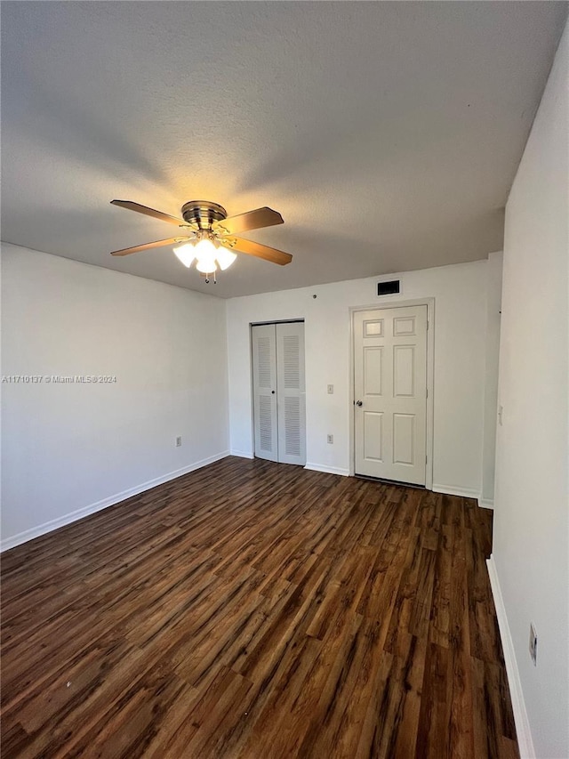 unfurnished bedroom featuring a textured ceiling, ceiling fan, dark wood-type flooring, and french doors