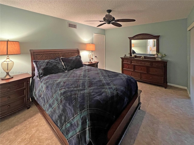 carpeted bedroom featuring ceiling fan and a textured ceiling