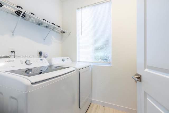 washroom with washer and dryer and light wood-type flooring