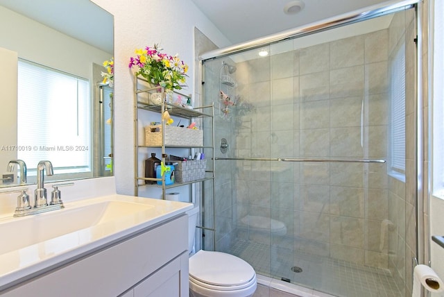 bathroom featuring vanity, toilet, and walk in shower