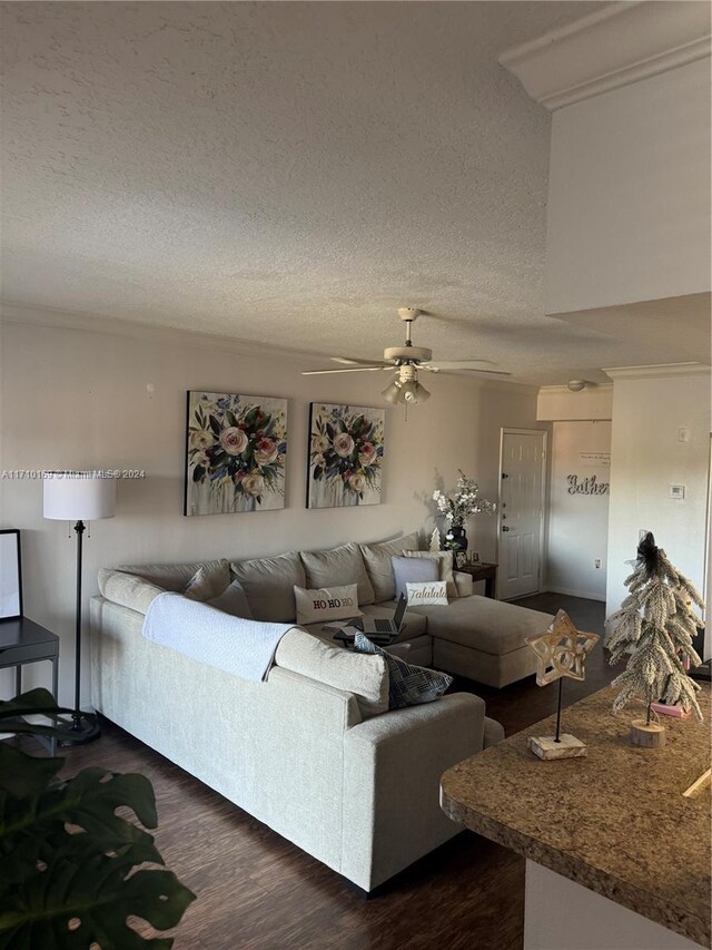 living room featuring a textured ceiling, ceiling fan, and dark wood-type flooring