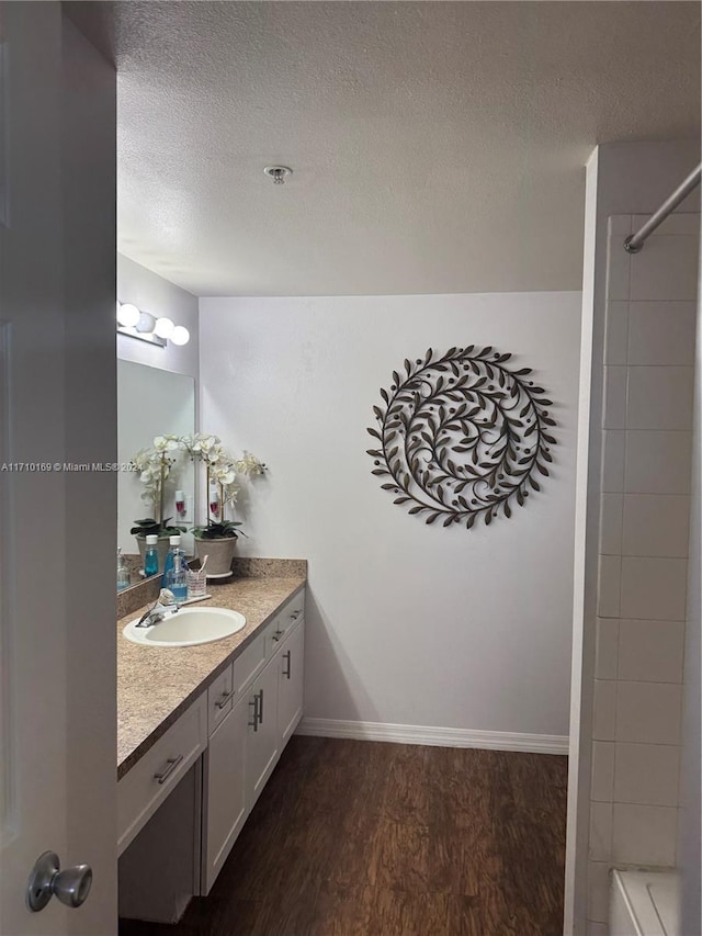 bathroom with a shower, hardwood / wood-style floors, vanity, and a textured ceiling