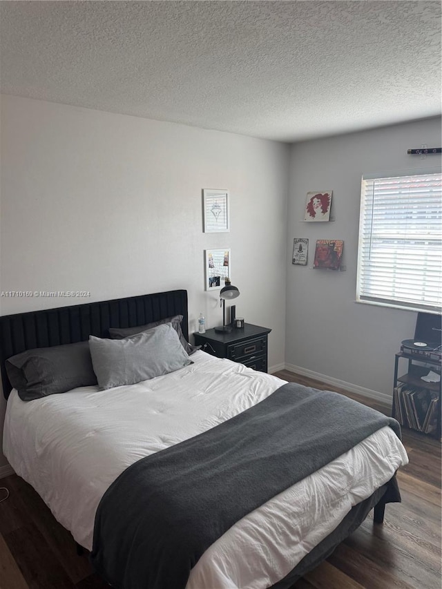 bedroom featuring a textured ceiling and dark wood-type flooring