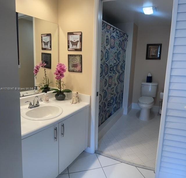 bathroom featuring tile patterned flooring, vanity, toilet, and a shower with curtain