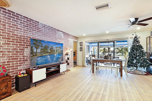 dining space with ceiling fan, a textured ceiling, and brick wall