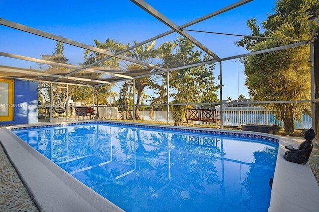 view of swimming pool featuring a water view and a lanai