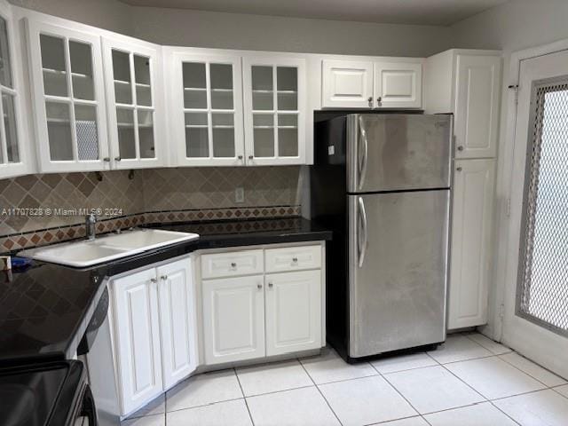 kitchen featuring backsplash, white cabinetry, sink, and stainless steel refrigerator