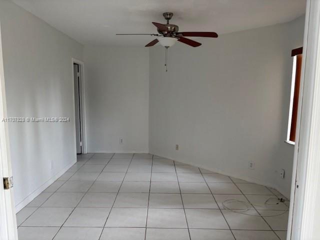 tiled spare room featuring ceiling fan