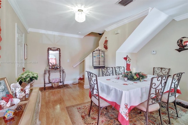 dining room featuring light wood-type flooring and crown molding