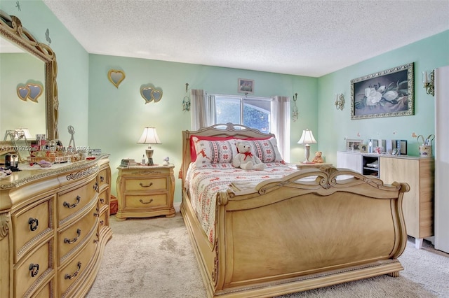 bedroom with light colored carpet and a textured ceiling