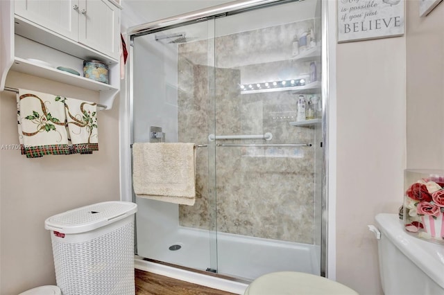 bathroom featuring hardwood / wood-style flooring, toilet, and an enclosed shower