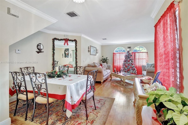 dining space featuring ornamental molding and light wood-type flooring