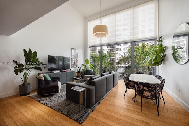 living room featuring a high ceiling and light wood-type flooring