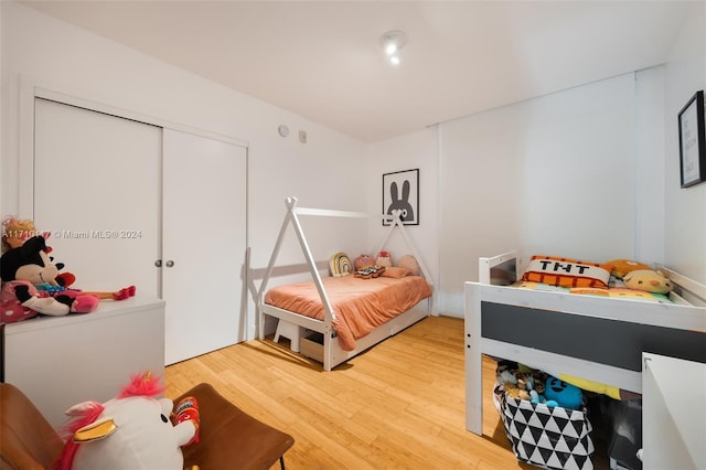 bedroom with wood-type flooring and a closet