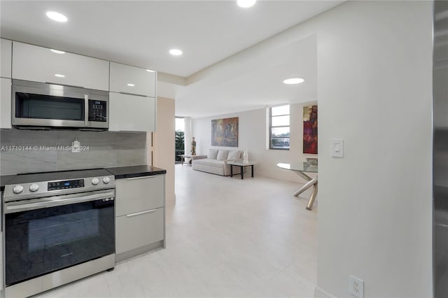 kitchen with tasteful backsplash, white cabinetry, and stainless steel appliances