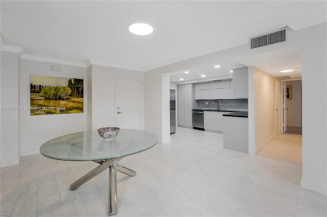 dining room featuring crown molding and sink