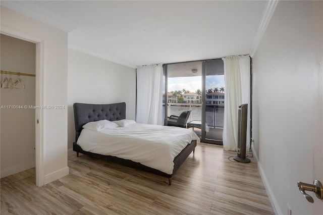 bedroom with crown molding and light wood-type flooring