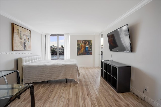 bedroom featuring light wood-type flooring and crown molding