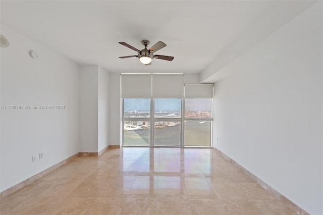 empty room with ceiling fan and floor to ceiling windows