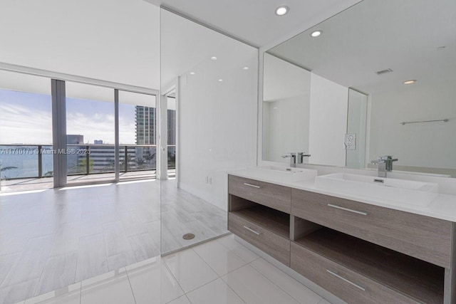 bathroom featuring a wall of windows, vanity, and tile patterned floors