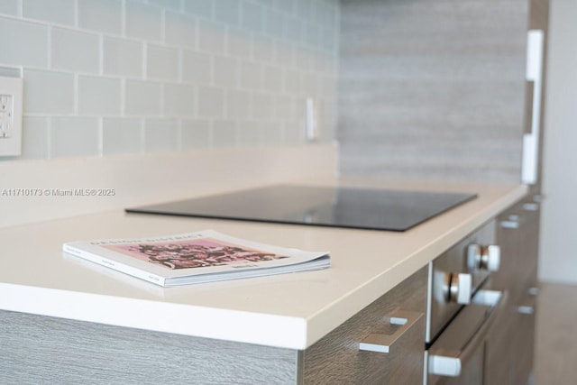 interior details with wall oven and black electric cooktop