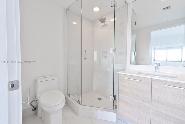 bathroom with toilet, vanity, tile patterned flooring, and a shower with shower door