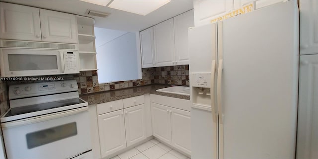 kitchen featuring white cabinets, light tile patterned flooring, white appliances, and sink