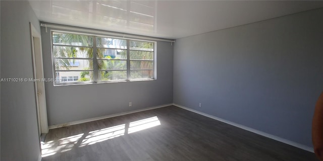 unfurnished room featuring dark wood-type flooring