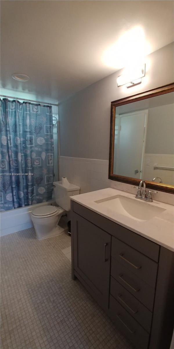 full bathroom with vanity, shower / tub combo, and toilet