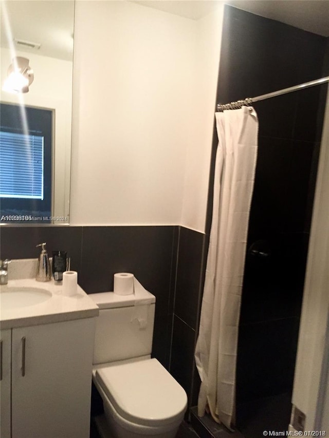 bathroom featuring vanity, a shower with shower curtain, and toilet