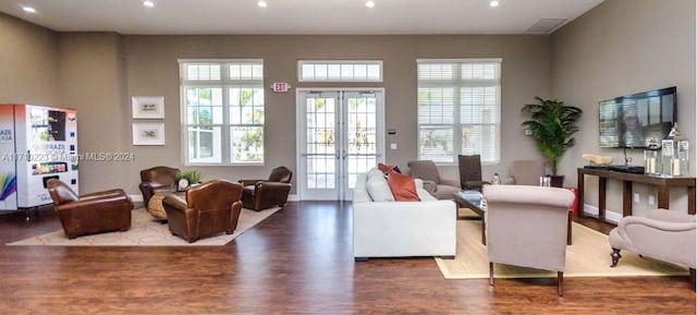 living room with a wealth of natural light, french doors, and dark wood-type flooring