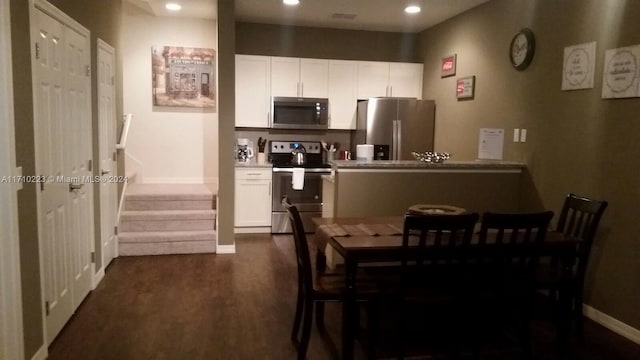 kitchen with dark hardwood / wood-style floors, white cabinetry, and appliances with stainless steel finishes