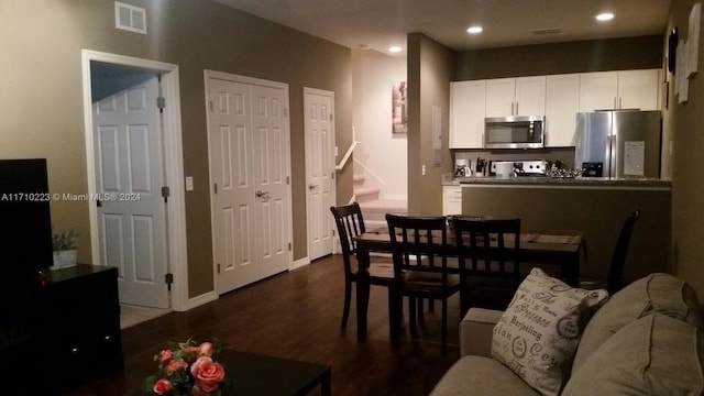 interior space with white cabinetry, dark wood-type flooring, and appliances with stainless steel finishes