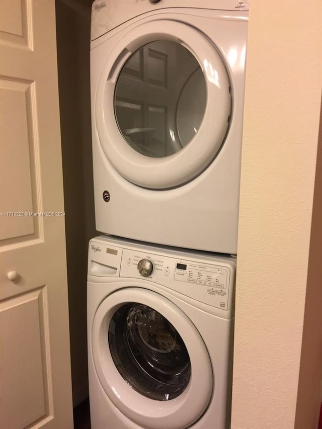 clothes washing area featuring stacked washing maching and dryer