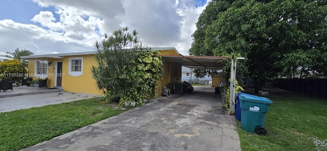 view of parking featuring a lawn and a carport