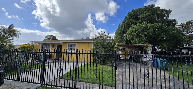 view of gate featuring a carport and a yard