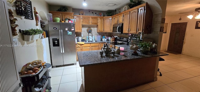 kitchen with a textured ceiling, light tile patterned floors, appliances with stainless steel finishes, and ceiling fan