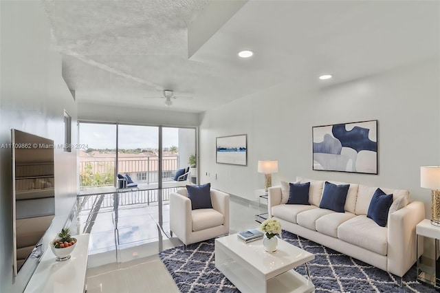 living room with ceiling fan and a textured ceiling