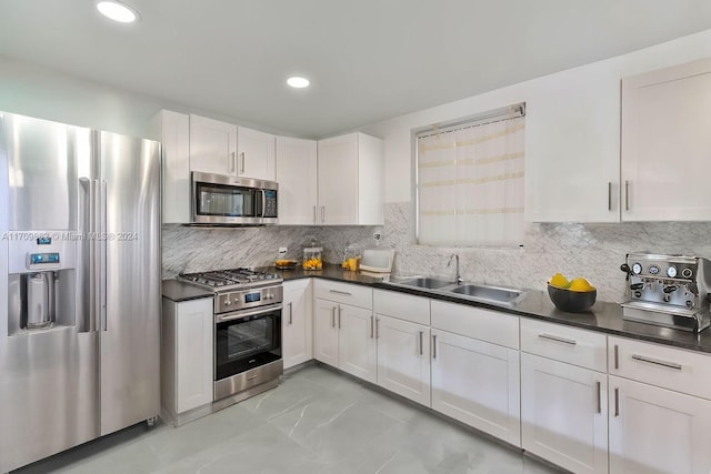 kitchen featuring white cabinets, backsplash, sink, and appliances with stainless steel finishes