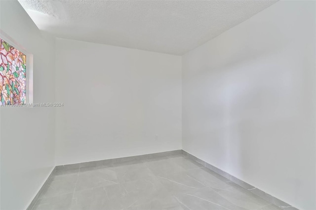 unfurnished room with a textured ceiling