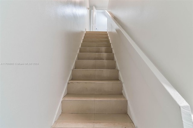 stairway with tile patterned floors