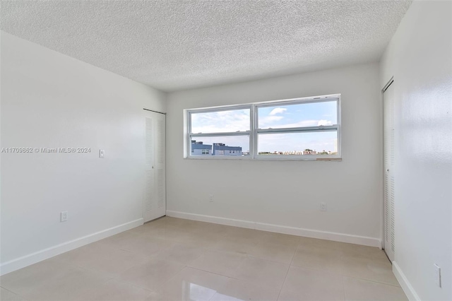 spare room featuring a textured ceiling and a wealth of natural light