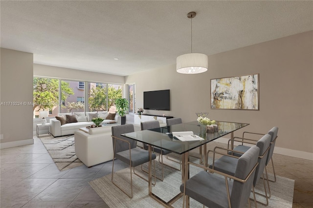 dining area featuring light tile patterned floors and a textured ceiling