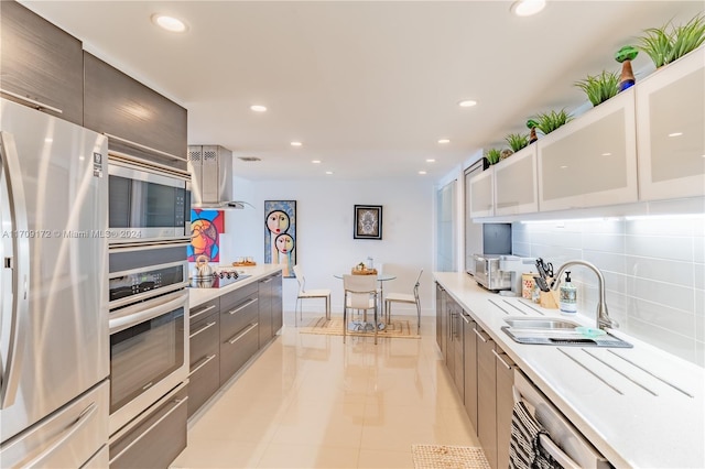 kitchen featuring backsplash, stainless steel appliances, sink, light tile patterned floors, and white cabinets