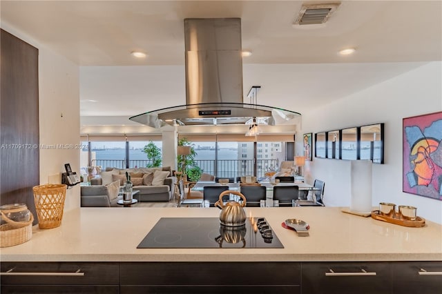 kitchen featuring black electric stovetop, dark brown cabinets, and island exhaust hood