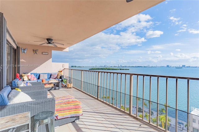 balcony featuring ceiling fan, a water view, and an outdoor hangout area