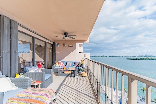 balcony with ceiling fan and a water view